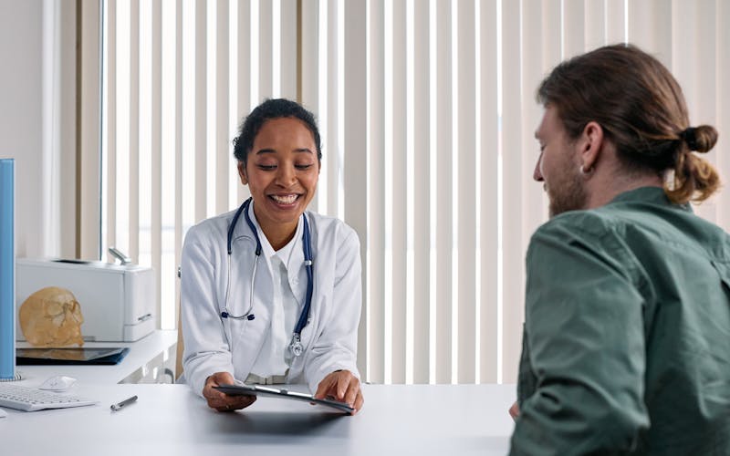 Licensed clinician providing an in-home wellness visit to a patient